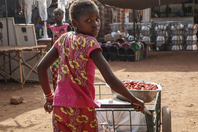 In this Wednesday, May 13, 2020, photo, a girl pushes a cart of food at a market in Tougan, Burkina Faso. Violence linked to Islamic extremists has spread to Burkina Faso's breadbasket region, pushing thousands of people toward hunger and threatening to cut off food aid for millions more. (Photo by Sam Mednick/AP Photo)