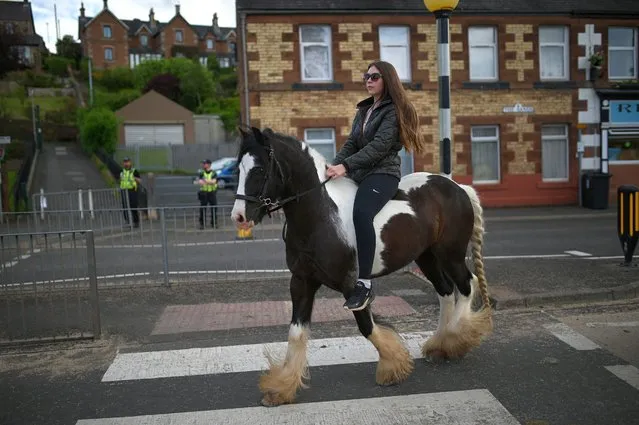 A woman rides a horse on the first day of the annual Appleby Horse Fair, in the town of Appleby-in-Westmorland, north west England on June 9, 2022. The annual event attracts thousands of travellers from across Britain to gather and buy and sell horses. (Photo by Oli Scarff/AFP Photo)