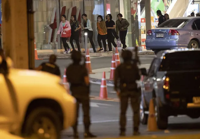People who were able to get out of Terminal 21 Korat mall walk outside the building in Nakhon Ratchasima, Thailand on Sunday, February 9, 2020. A soldier who holed up in a popular shopping mall in northeastern Thailand shot multiple people on Saturday, killing at least 20 and injuring 31 others, officials said. (Photo by Sakchai Lalitkanjanakul/AP Photo)