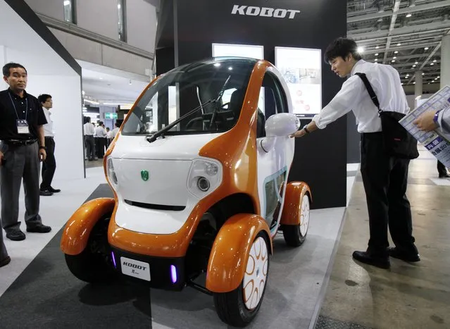 A visitor looks at a Kobot mini single-seater electric vehicle displayed at the Eco Office Expo in Tokyo on July 13, 2012