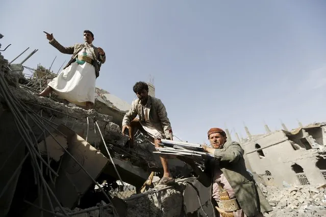 Houthi militants salvage documents from under the rubble of the offices of the education ministry's workers union, destroyed by Saudi-led air strikes, in Yemen's northwestern city of Amran August 19, 2015. (Photo by Khaled Abdullah/Reuters)
