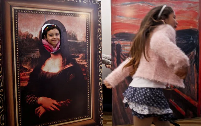 In this August 20, 2016 photo, transgender girls Selenna, right, and Genesis who poses inside a Mona Lisa painting, play at the Artequin museum during celebrations marking Transgender Children's Day in Santiago, Chile. Families of trans children are demanding greater acceptance, which has fed the broader debate about gender rights in a country so socially conservative that it legalized divorce just 13 years ago. (Photo by Esteban Felix/AP Photo)