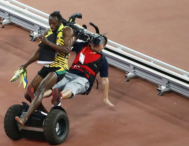 A TV cameraman drives into Usain Bolt of Jamaica after the men's 200m final during the Beijing 2015 IAAF World Championships at the National Stadium, also known as Bird's Nest, in Beijing, China, 27 August 2015. Bolt won the race. (Photo by Rolex Dela Pena/EPA)