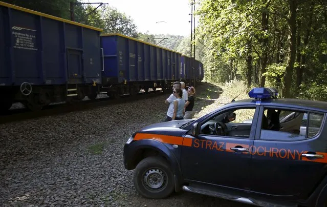A railway security guards' car is seen next to people observing a cargo train travelling in an area where a Nazi train is believed to be at, in Walbrzych, southwestern Poland August 30, 2015. Poland said on Friday it was almost certain it had located the Nazi train rumored to have gone missing near the close of World War Two loaded with guns and jewels. (Photo by Kacper Pempel/Reuters)