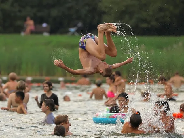 Teenagers play in the pond in Sokolniki Park during hot weather in Moscow, Russia on August 5, 2022. (Photo by Evgenia Novozhenina/Reuters)