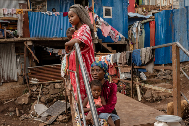 Women rest on a footbridge over a stream filled with debris in the Kaweni slum in the French Indian Ocean island of Mayotte, Thursday, December 19, 2024, after Cyclone Chido. (Photo by Adrienne Surprenant/AP Photo)