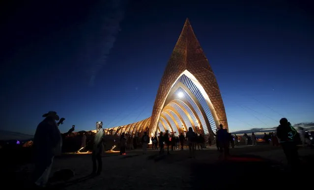 People gather before sunrise at the Temple of Promise during the Burning Man 2015 “Carnival of Mirrors” arts and music festival in the Black Rock Desert of Nevada, September 3, 2015. (Photo by Jim Urquhart/Reuters)