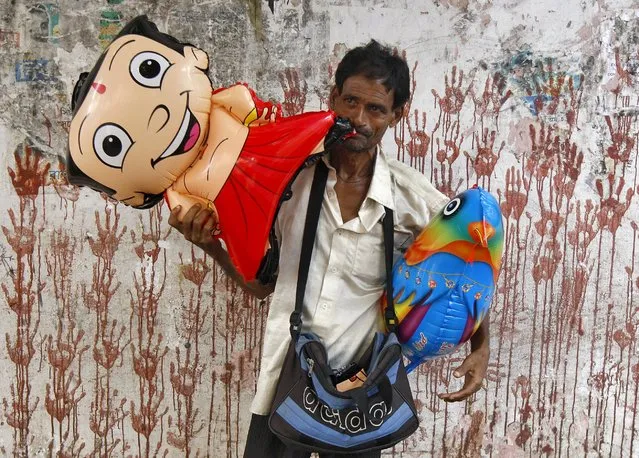 A vendor inflates a toy balloon for sale at a roadside in Kolkata, India, September 1, 2015. (Photo by Rupak De Chowdhuri/Reuters)
