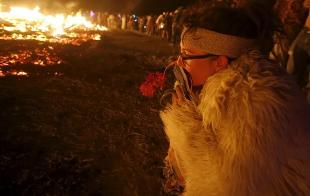 KT Cubb kneels at the burning remains of the Temple of Promise during the Burning Man 2015 “Carnival of Mirrors” arts and music festival in the Black Rock Desert of Nevada, September 6, 2015. (Photo by Jim Urquhart/Reuters)