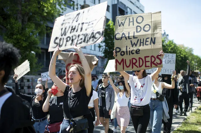 People protest in Berlin, Germany, Sunday, May 31, 2020 after the violent death of the African-American George Floyd by a white policeman in the USA against racism and police violence, among other things with a sign “Who do call when police murders”. (Photo by Bernd von Jutrczenka/dpa via AP Photo)