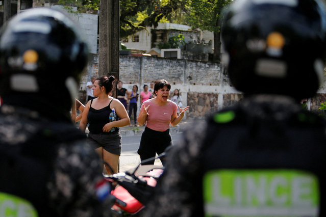 Relatives of inmates react to police during a security operation after a riot broke out at the Tacumbu penitentiary, in Asuncion, Paraguay on December 18, 2023. (Photo by Cesar Olmedo/Reuters)