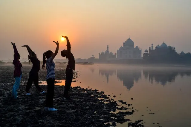 Children exercise on the banks of the Yamuna River near the Taj Mahal in Agra at sunrise on October 17, 2022. (Photo by Pawan Sharma/AFP Photo)