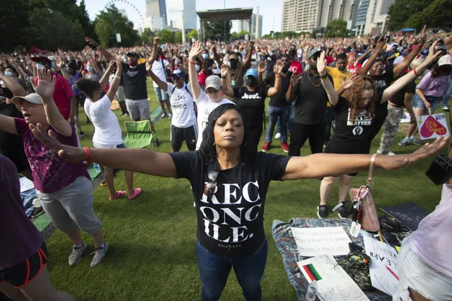 A woman prays during an event hosted by OneRace Movement at Atlanta’s Centennial Olympic Park to commemorate Juneteenth, the date of the emancipation of enslaved African Americans in the U.S., on Friday, June 19, 2020. OneRace Movement, a religious organization, hosted the event in an effort to call for change and unify across races, classes, denominations and culture. (Photo by John Bazemore/AP Photo)