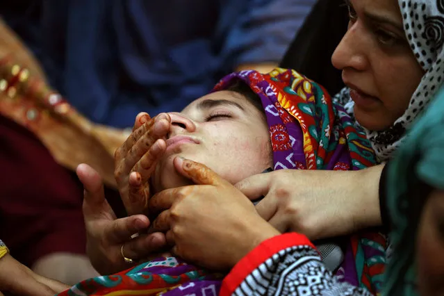 Relatives of Irfan Ahmed, who according to local media died after being hit by a tear gas canister fired by security forces, mourn his death in Srinagar as the city remains under curfew following weeks of violence in Kashmir, August 22, 2016. (Photo by Cathal McNaughton/Reuters)