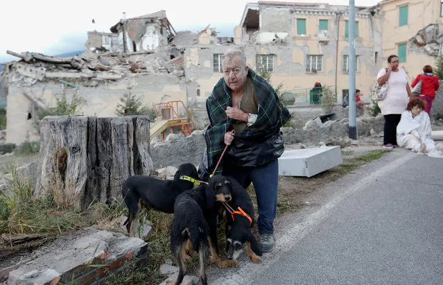 A man stands with dogs following an earthquake in Amatrice, central Italy, August 24, 2016. (Photo by Remo Casilli/Reuters)