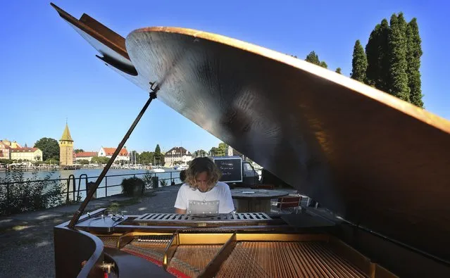A picture made available on 26 August 2016 shows Florian Palatz, advisor to the project “Open Piano for Refugees”, playing a piano in the harbor of Lindau, Germany, 25 August 2016. As part of the project people will be invited to play the instrument, which will be made available from 25 to 28 August 2016. Donations for the performances will go to music projects with refugees. (Photo by Karl-Joself Hildenbrand/EPA)