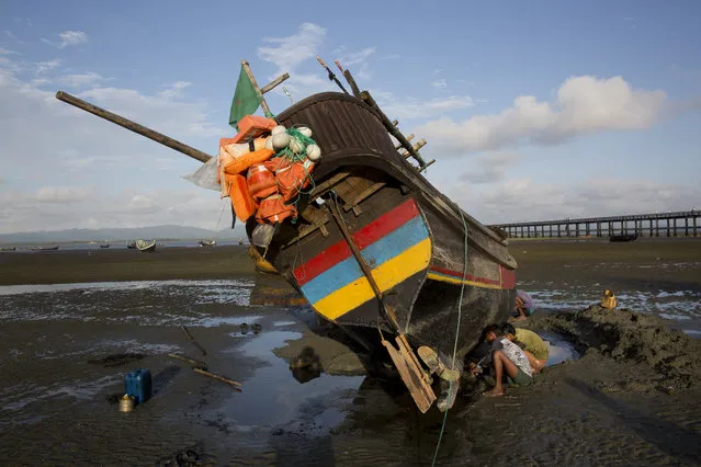 In this September 21, 2017, local villagers repair a fishing boat in Shah Porir Dwip, an island by the Bay of Bengal at Bangladesh’s southern tip. This island can mean both hope and death for the Rohingya Muslims who are desperate to escape the violence that has engulfed their lives in Myanmar’s Rakhine state. High tide or low, day or night, rough waters or calm, when they can find a boat, the Rohingya take their chance to flee to Bangladesh. More than 430,000 have left Myanmar in less than a month. (Photo by Bernat Armangue/AP Photo)