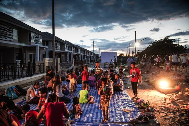 “Juxtapose”. A view of the meeting place reveals the proximity of two very different worlds. One of affluence and comfort where this people group labors to build the homes towering over the muddy village they return to at the end of every day. Photo location: Chiang Mai, Thailand. (Photo and caption by Natalie Roush/National Geographic Photo Contest)