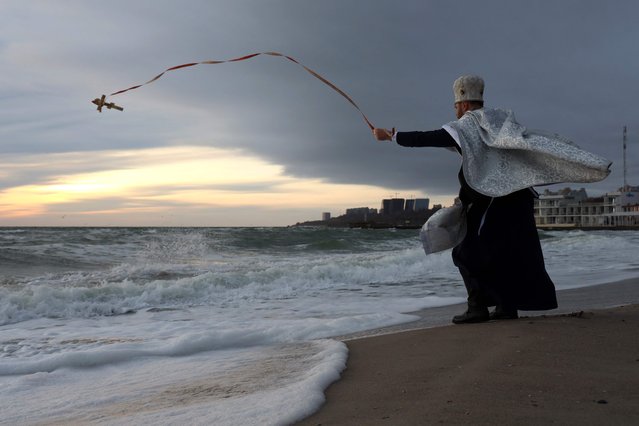 A priest of the Orthodox Church of Ukraine blesses waters of the Black Sea during the Orthodox Epiphany celebration in Odesa, on January 6, 2024, amid the Russian invasion of Ukraine. (Photo by Oleksandr Gimanov/AFP Photo)