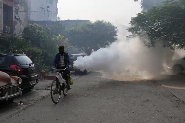 A municipal worker fumigates an area to prevent the spread of mosquito-borne diseases in Prayagraj, in the northern state of Uttar Pradesh, India, Thursday, November 17, 2022. (Photo by Rajesh Kumar Singh/AP Photo)