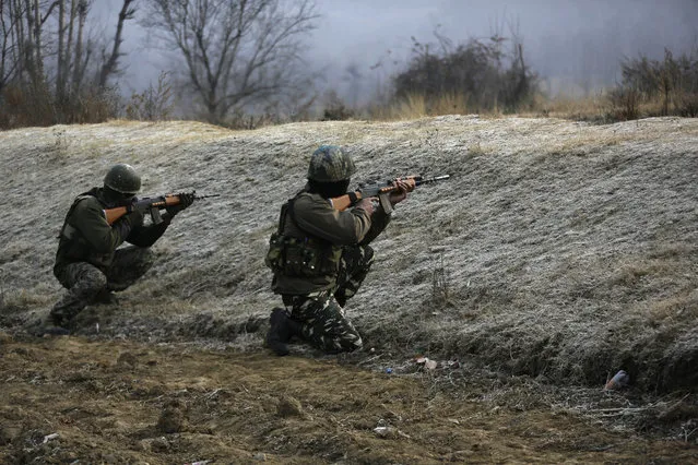 Indian paramilitary force soldiers take position at the site where suspected rebels stormed a paramilitary camp at southern Lethpora village in Indian controlled Kashmir, Sunday, December 31, 2017. A number of Indian soldiers and suspected militants were killed Sunday after rebels stormed a paramilitary camp in disputed Kashmir, officials said. (Photo by Mukhtar Khan/AP Photo)