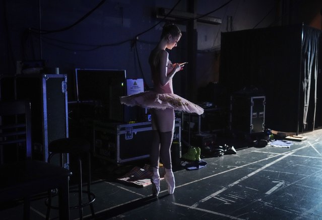A member of the National Ballet of Ukraine looks at her phone as she prepares for a performance of “Nadiya Ukraine” (Hope for Ukraine) on opening night in Vancouver, on Monday, February 5, 2024. Twenty-three dancers are on a Canadian tour highlighting Ukrainian culture through traditional dance while also supporting the war effort by collecting donations from the audience for Ukraine First Lady Olena Zelenska's Foundation and Humanite. (Photo by Darryl Dyck /The Canadian Press via AP Photo)