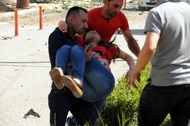 People carry a wounded person after a car bomb attack in the city center of Van, eastern Turkey, Monday, September 12, 2016. (Photo by DHA via AP Photo)