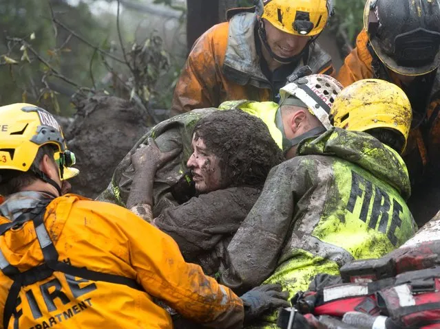 Firefighters rescue 14-year-old Lauren Cantin after she was trapped inside a destroyed home in Montecito, Calif on January 9, 2018. She was discovered when firefighters using dogs in the search heard a scream. Using the jaws of life and other tools, rescuers sheared off debris from around Cantin. They worked for over six hours before freeing her Tuesday morning. (Photo by Kenneth Song/Santa Barbara News-Press/Reuters)
