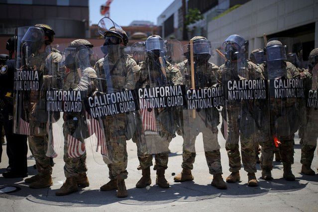 Members of the California National Guard carry shields during a protest against federal immigration sweeps in downtown Los Angeles, California, U.S., June 8, 2025. (Photo by Daniel Cole/Reuters)