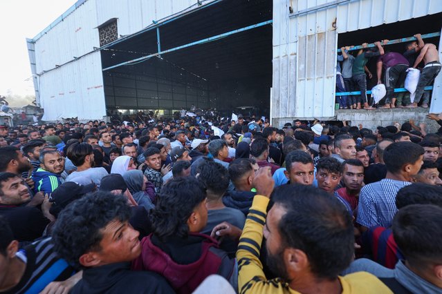 Displaced Palestinians ferry bags of food aid after storming a World Food Programme warehouse in Deir el-Balah in the central Gaza Strip on May 28, 2025. The United Nations on May 28 condemned a US-backed aid system in Gaza following a chaotic food distribution where 47 people were injured, after Israel allowed supplies in at a trickle last week, easing a full blockade imposed on the besieged Palestinian territory for over two months. (Photo by Eyad Baba/AFP Photo)