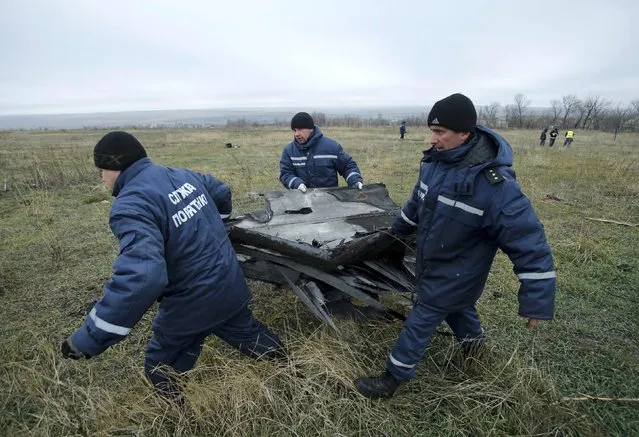 Local workers carry wreckage of the Malaysia Airlines Boeing 777 plane (flight MH17) at the site of the plane crash near the settlement of Grabovo in the Donetsk region November 16, 2014. (Photo by Antonio Bronic/Reuters)