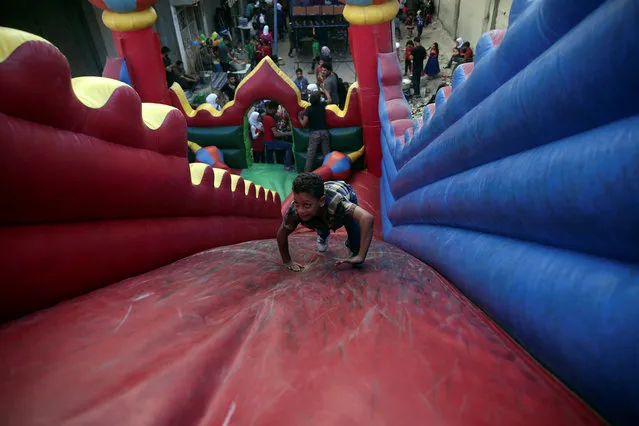 Children play inside an inflatable castle on the last day of Eid al-Adha celebrations in the rebel held besieged town of Hamouriyeh, eastern Ghouta, near Damascus, Syria September 15, 2016. (Photo by Bassam Khabieh/Reuters)