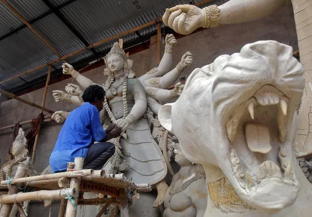 An artisan works on an idol of Hindu goddess Durga at a pandal, or a temporary platform, ahead of the Durga Puja festival, in Agartala, India, September 25, 2016. (Photo by Jayanta Dey/Reuters)