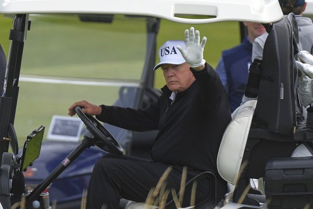 President Donald Trump waves to reporters as he sits in his golf cart at the Trump Turnberry golf course in Turnberry, Scotland, Saturday, July 26, 2025.(Phoot by Alastair Grant/AP Photo)