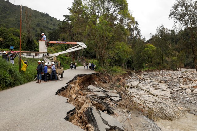 Members of the National Electric Corporation reconnect electrical wiring on a fallen road next to the river after floods, in Tabay, Venezuela, on June 28, 2025. (Photo by Leonardo Fernandez Viloria/Reuters)