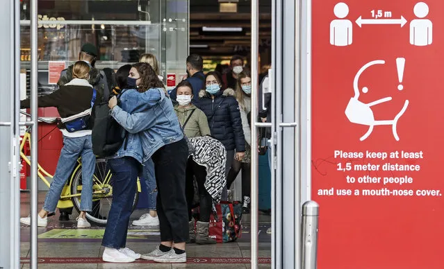 People are ordered to wear face masks and keep distance due to the coronavirus pandemic in Cologne, Germany, Thursday, October 22, 2020. The city exceeded the important warning level of 50 new infections per 100,000 inhabitants in seven days. More and more German cities become official high risk corona hotspots with travel restrictions within Germany. (Photo by Martin Meissner/AP Photo)