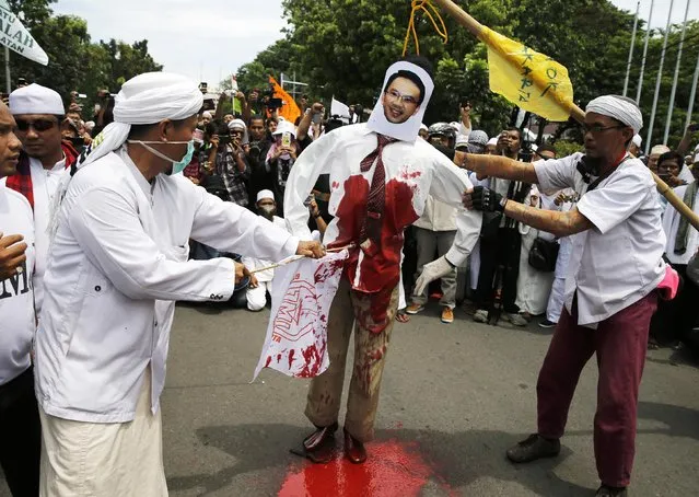 Members of the hardline Islamic group, the Islamic Defenders Front (FPI), stab an effigy of Jakarta Governor Basuki Tjahaja Purnama or Ahok as they reject Ahok as their governor in front of Jakarta's city hall, December 1, 2014. Jakarta's first Christian governor in nearly 50 years was sworn in two weeks ago, despite protests from religious hardliners opposing a non-Muslim taking over one of Indonesia's most powerful political jobs. (Photo by Reuters/Beawiharta)