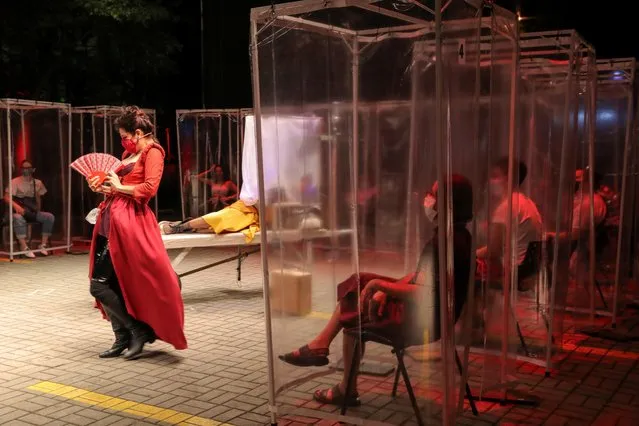 Spectators keep social distance inside individual plastic cabins as they watch the theatre play “Volpone Protocol” staged by Bendita Trupe during the coronavirus disease (COVID-19) outbreak in Sao Paulo, Brazil on October 28, 2020. (Photo by Amanda Perobelli/Reuters)