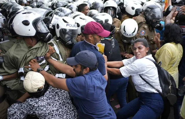 Anti government protesters scuffle with police officers as police blocked their protest march in Colombo, Sri Lanka, Wednesday, November 2, 2022. The protestors were demanding the release of two detained  protest leaders and to end the government’s crackdown on protests against an unprecedented economic crisis that has engulfed the island nation for months. (Photo by Eranga Jayawardena/AP Photo)