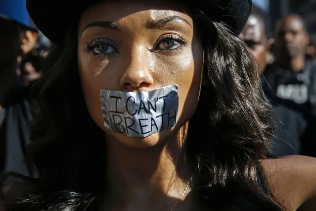 Logan Browning, with duct tape over her mouth, joins demonstrators protesting against police violence, including the July chokehold death of unarmed black man Eric Garner in New York, as they march near the area where LAPD shot an assault suspect on December 5, in Hollywood, California December 6, 2014. Police responding to an assault with a deadly weapon call shot the man near the popular Hollywood and Highland complex Friday night. (Photo by Patrick T. Fallon/Reuters)