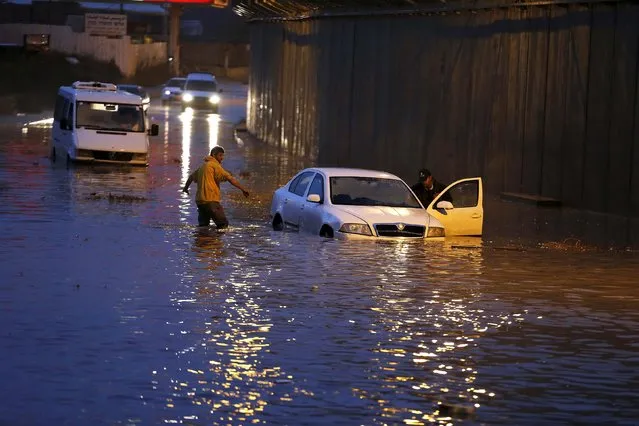 A driver stands next to his car on a flooded road after heavy rainfall in Jerusalem November 5, 2015. (Photo by Ammar Awad/Reuters)