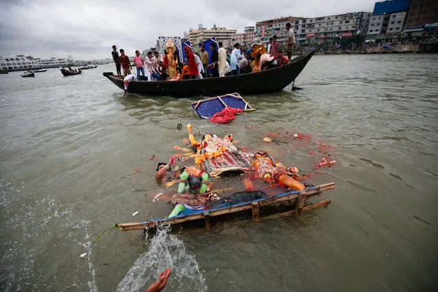 Hindu devotees immerse an idol of the goddess Durga in the Burigonga river on the last day of the Durga Puja festival in Dhaka, Bangladesh, October 11, 2016. (Photo by Mohammad Ponir Hossain/Reuters)