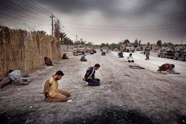 Villagers arrested by U.S. forces sit bound in the street after a roadside bomb attack that left four Americans and one Iraqi boy dead in Baqubah, Iraq, in March 2007. (Photo by Yuri Kozyrev/Noor Photo)