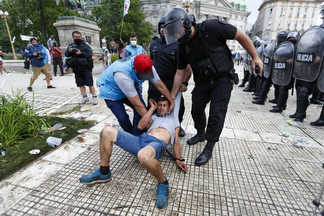 Police detain a soccer outside the presidential palace where Diego Maradona is lying in Buenos Aires, Argentina, Thursday, November 26, 2020. (Photo by Natacha Pisarenko/AP Photo)
