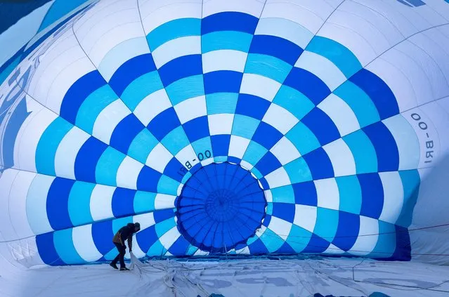 A participant prepares a balloon during the 43rd International Hot Air Balloon Festival in Chateau-d'Oex, Switzerland on January 24, 2023. (Photo by Denis Balibouse/Reuters)