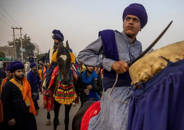 A group of Nihangs (Sikh warriors) arrive to take part in a protest against the newly passed farm bills at Singhu border near Delhi, India, December 3, 2020. Tens of thousands of growers have camped out at the entrance to Delhi in protest against the laws seeking to deregulate the agriculture sector. The farmers fear the laws could pave the way for the government to stop buying grains at guaranteed prices, leaving them at the mercy of private buyers. (Photo by Danish Siddiqui/Reuters)