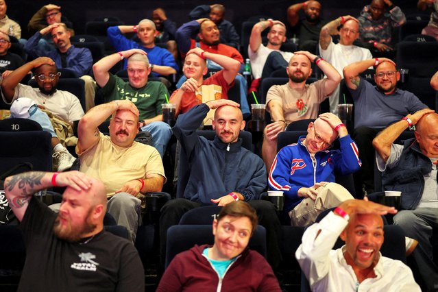 Fans with shaved heads sit in a cinema hall waiting for a free preview of Yorgos Lanthimos’s new film “Bugonia”, in Culver City, California on October 21, 2025. (Photo by Daniel Cole/Reuters)