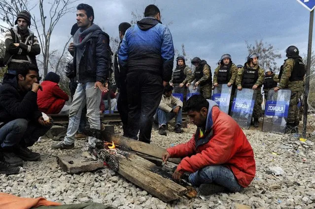 Macedonian policemen stand guard as migrants wait to cross the Greek-Macedonian borders near the village of Idomeni, Greece November 22, 2015. (Photo by Alexandros Avramidis/Reuters)