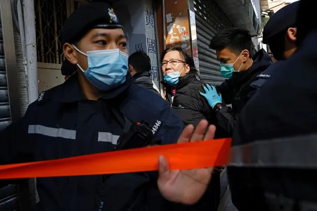 Daniel Wong Kwok-tung, a lawyer who tried to help the 12 people detained in mainland China, is escorted by police as he returns to his office in Hong Kong, China, January 14, 2021. Wong was reportedly arrested by national security police officers for aiding twelve Hong Kong protesters in their bid to escape to Taiwan last August. (Photo by Tyrone Siu/Reuters)