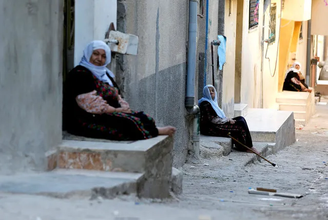 Palestinian refugee women sit if front their homes during the holy month of Ramadan, in Al-Baqaa Palestinian refugee camp, near Amman, Jordan, May 29, 2018. (Photo by Muhammad Hamed/Reuters)